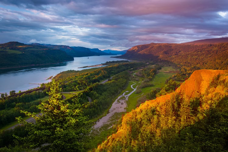 View over a mountain of a river with clouds in the sky